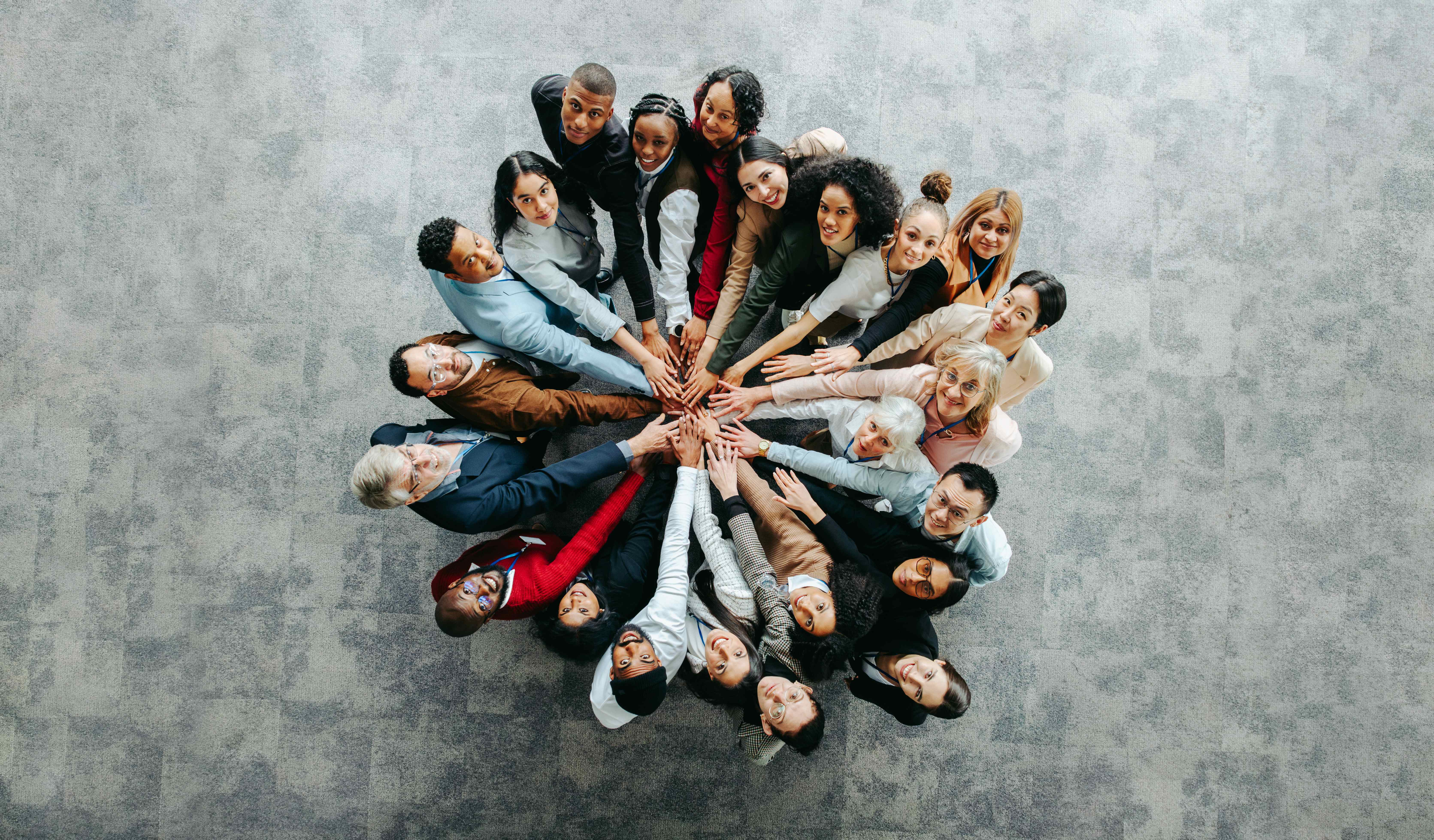 Diverse team of professionals stacking their hands together in a circle