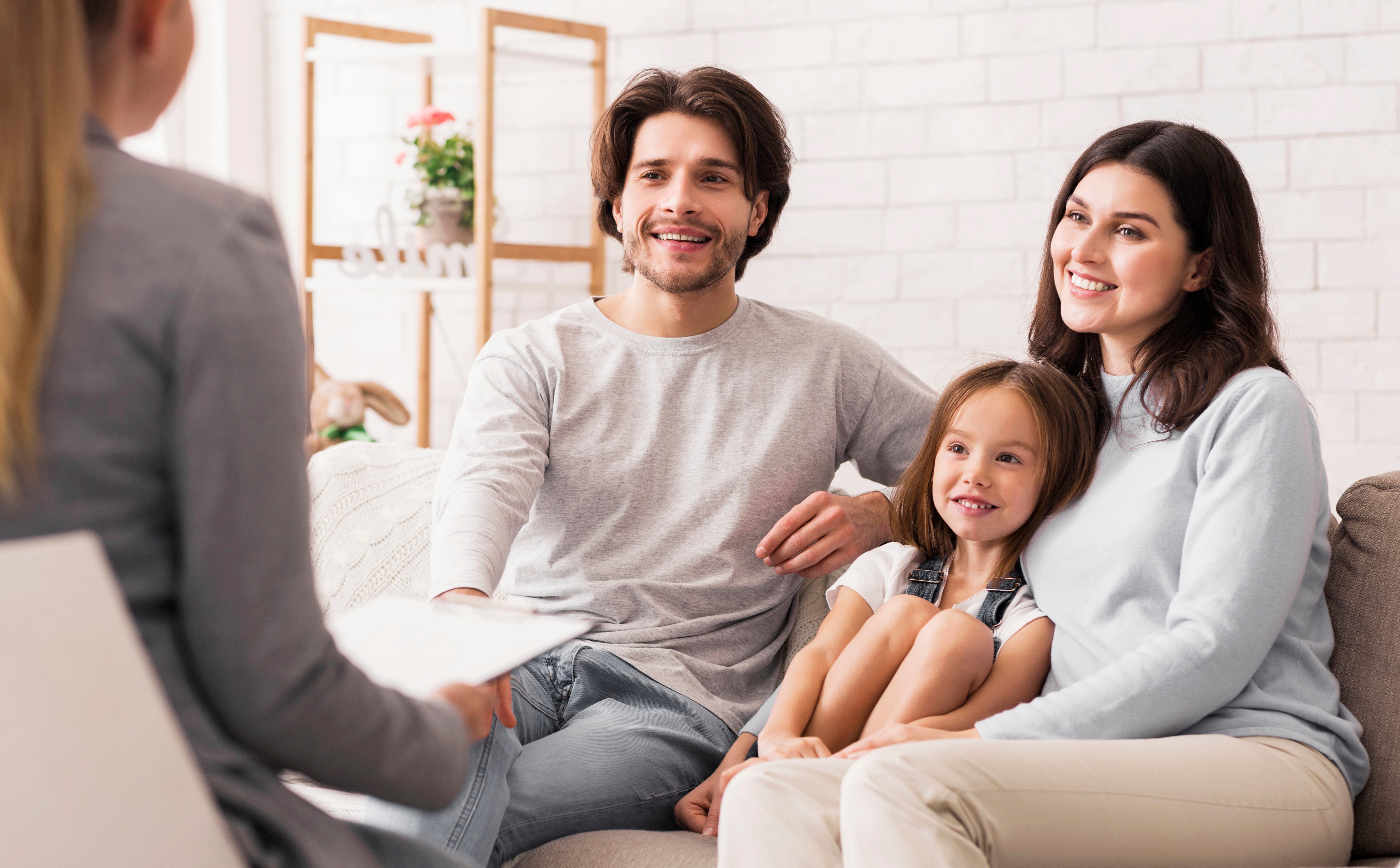 Parents and their child meeting with an ABA professional on a couch